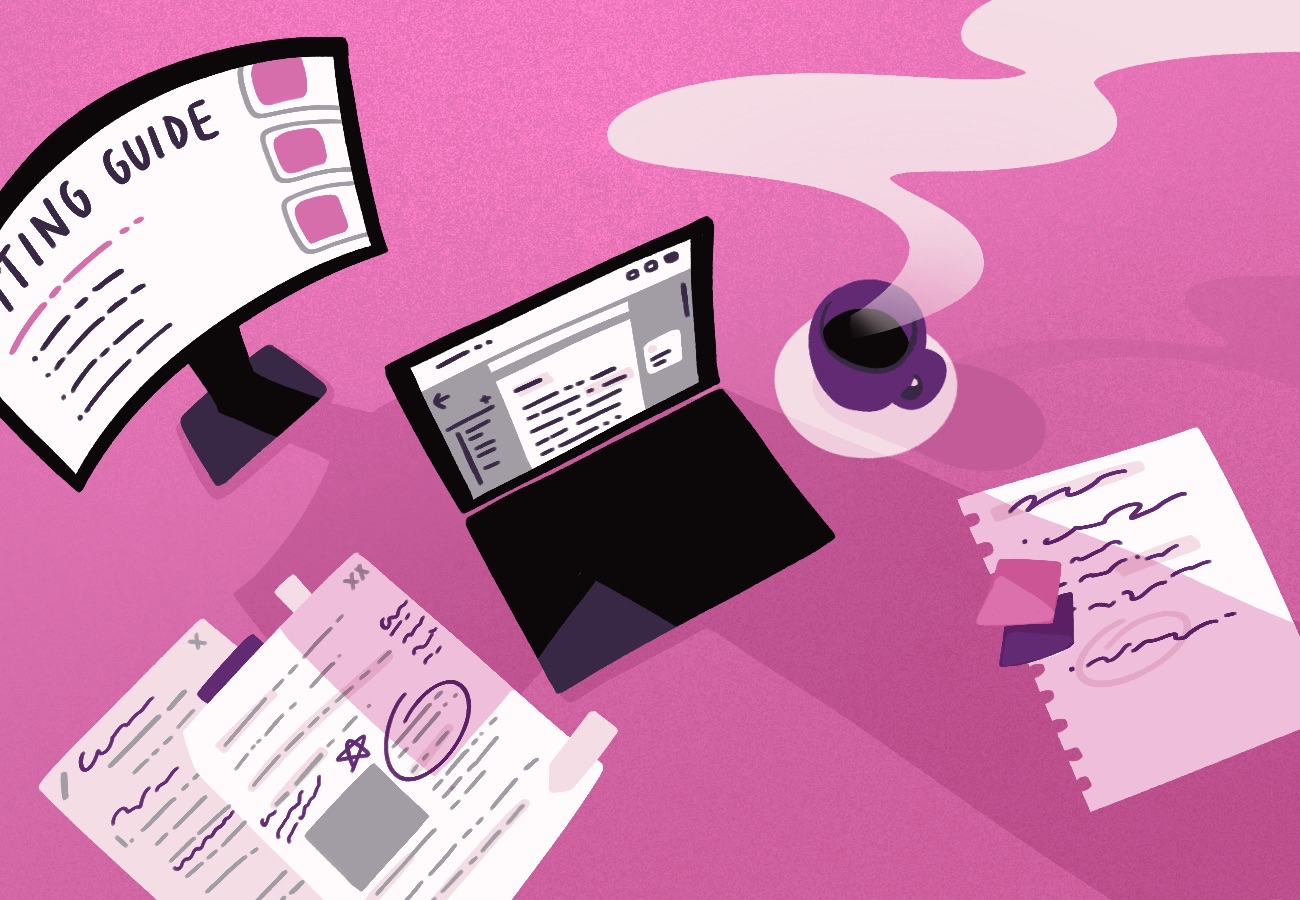 A desk with a monitor, a laptop, and an few annotated papers strewn across the table